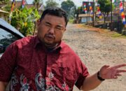 Anggota Fraksi PDI Perjuangan DPRD Kabupaten Garut, Yudha Puja Turnawan, berdiri di pinggir jalan Kecamatan Cihurip yang kondisinya rusak.