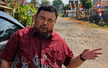 Anggota Fraksi PDI Perjuangan DPRD Kabupaten Garut, Yudha Puja Turnawan, berdiri di pinggir jalan Kecamatan Cihurip yang kondisinya rusak.